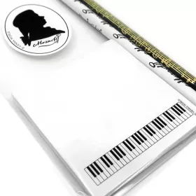 Sada psacích potřeb bílé a černé tužky s notami a lepícím bločkem s klaviaturou - partitura Mozart